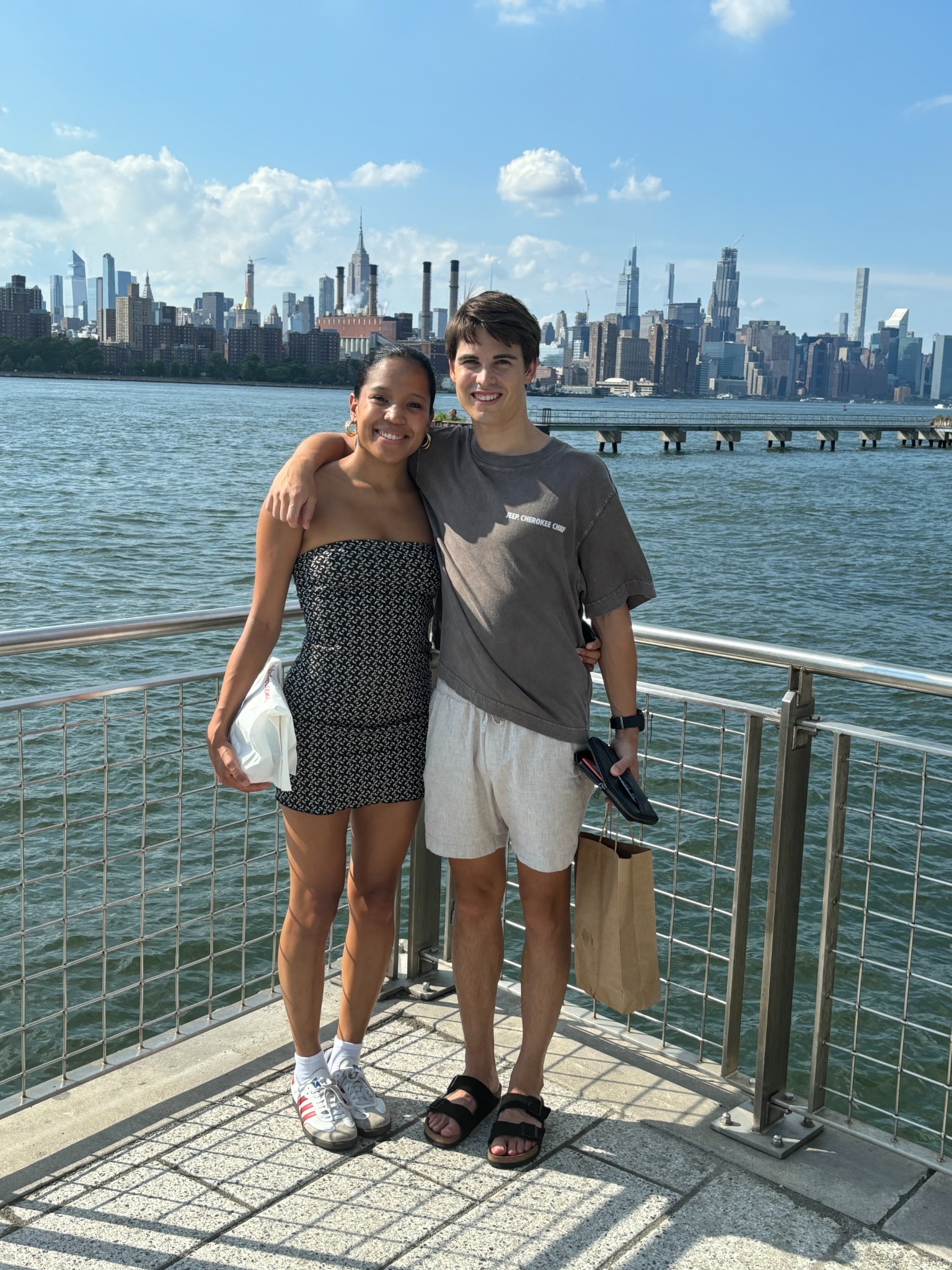 Oscar and Amber by the water with a city skyline