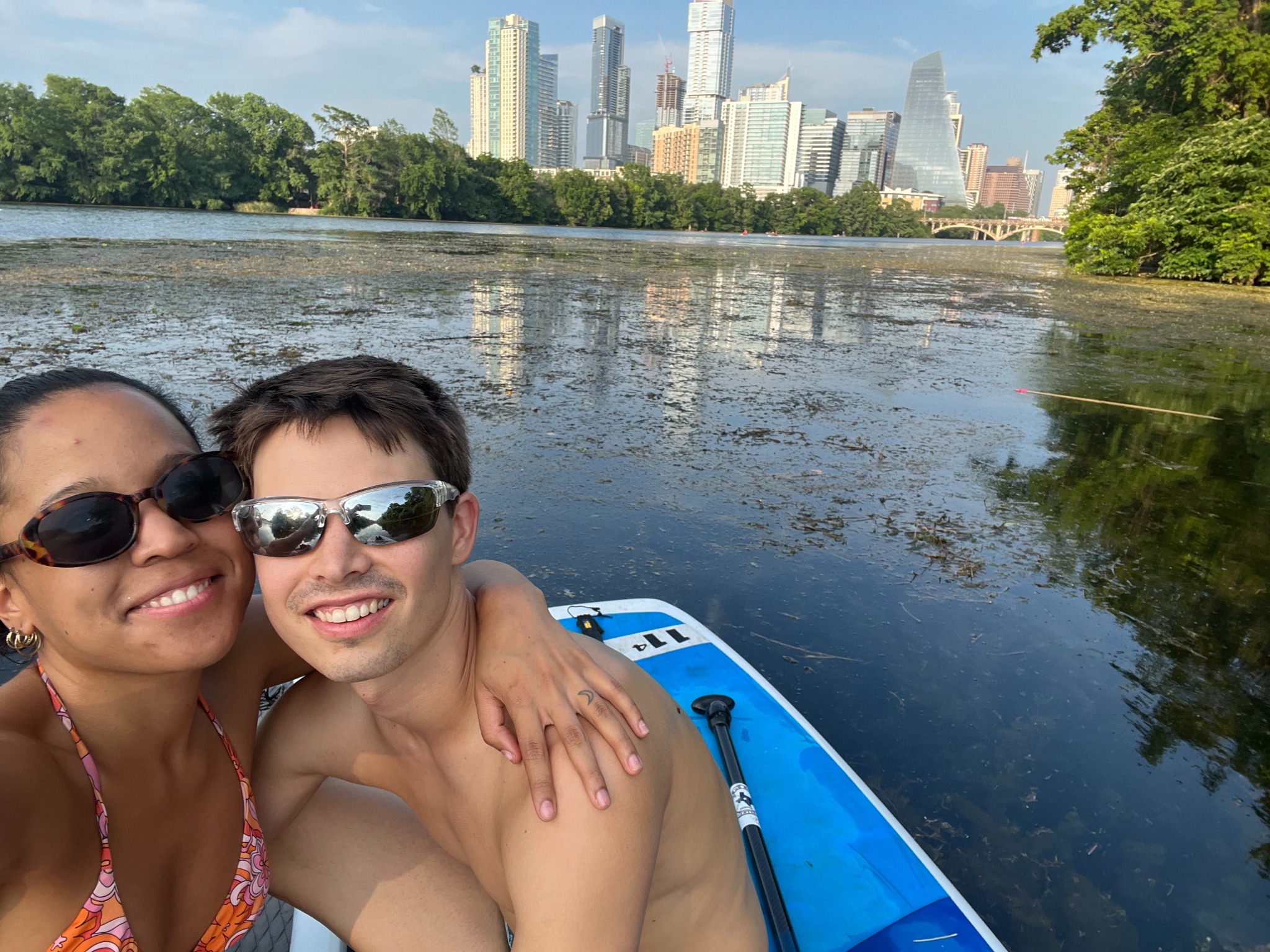 Oscar and Amber on a boat with a city skyline behind them