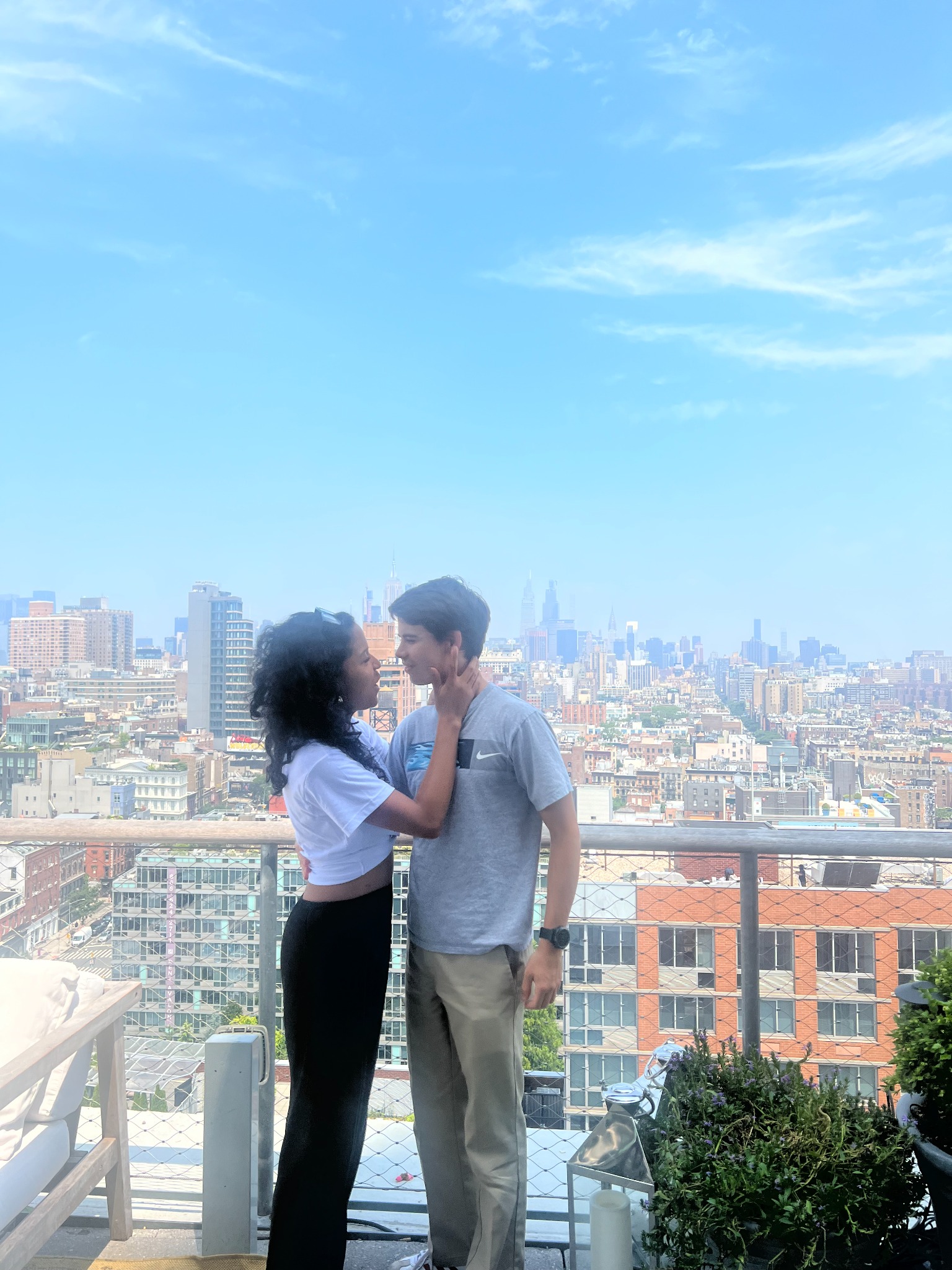 Oscar and Amber kissing on a balcony