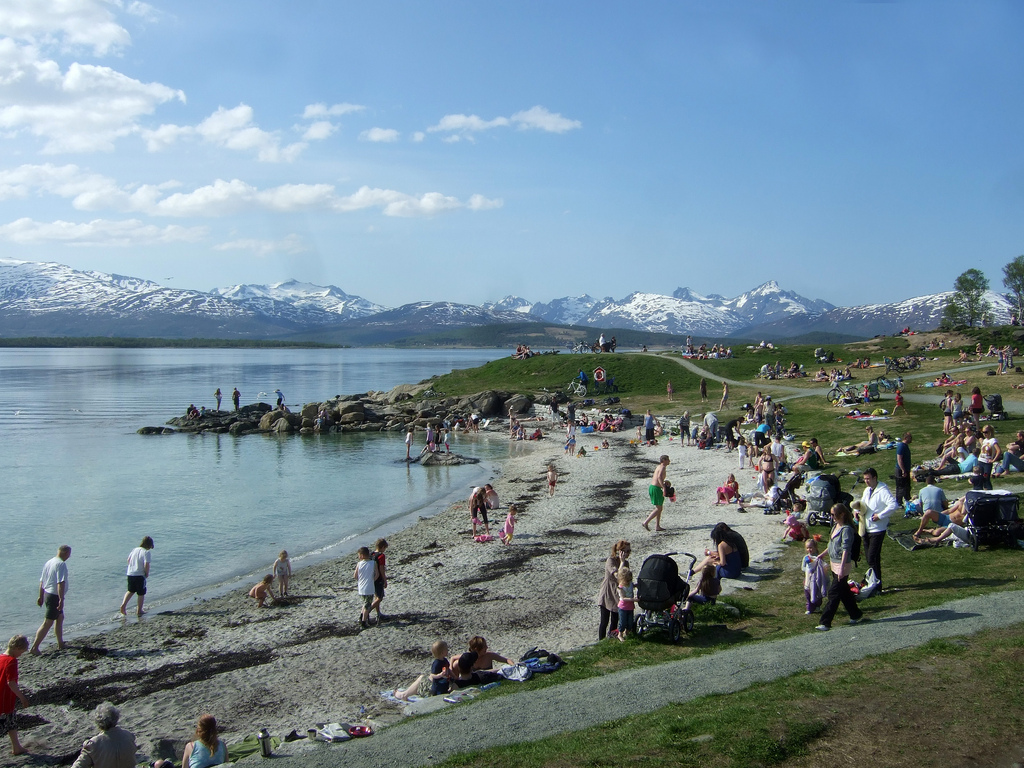 Telegrafbukta beach with blue water and snow-capped mountains across the fjord